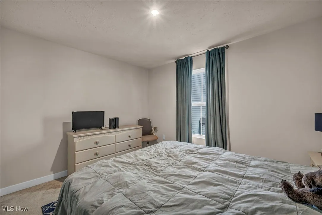 Bedroom with a textured ceiling and carpet flooring