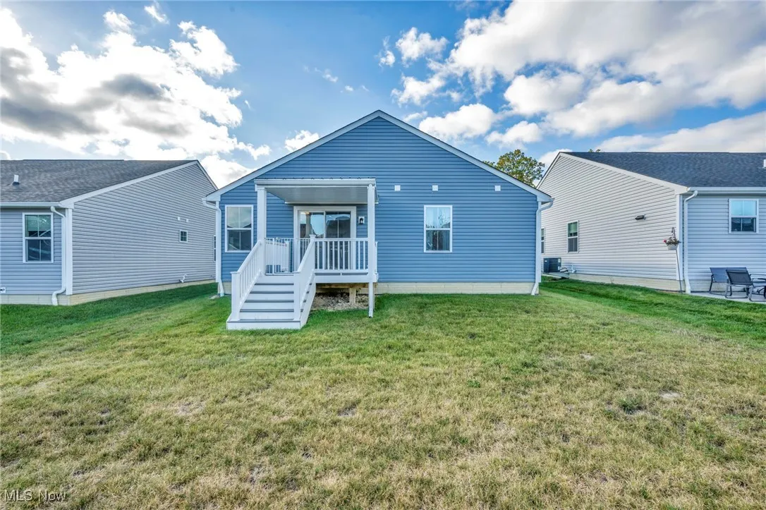 Rear view of house with a deck and a yard