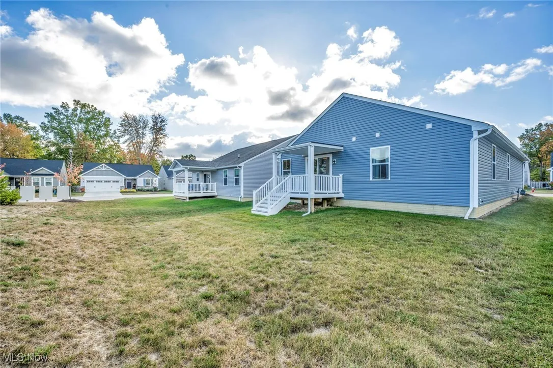 Rear view of property with a lawn and a wooden deck