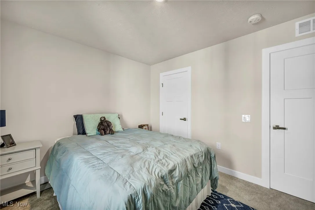 Carpeted bedroom with baseboards and a textured ceiling
