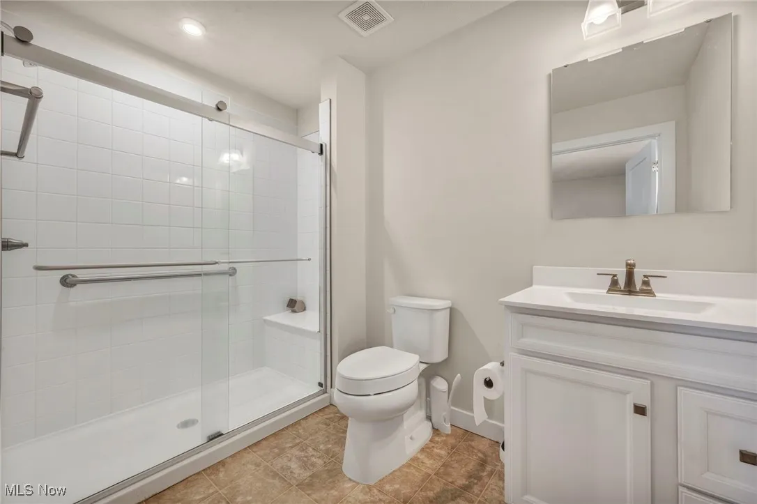 Full bathroom with vanity, a stall shower, and light tile patterned flooring