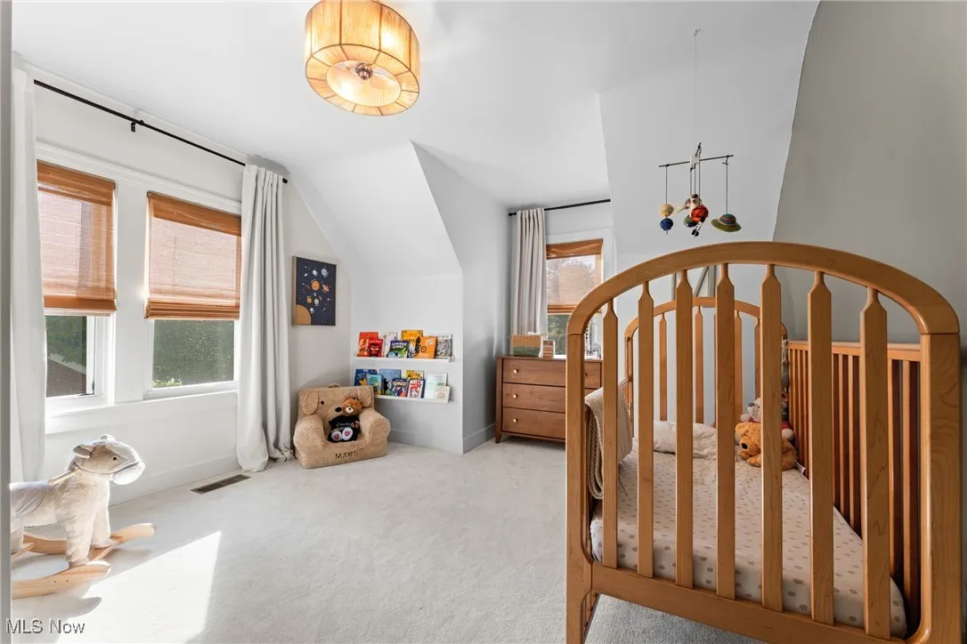 Bedroom featuring a nursery area and carpet