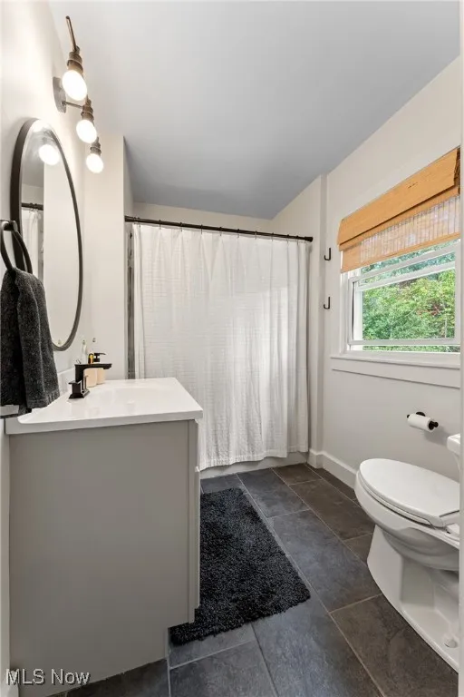 Bathroom featuring a shower with curtain and vanity