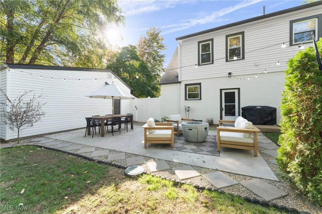 Rear view of house with a patio and an outdoor living space with a fire pit