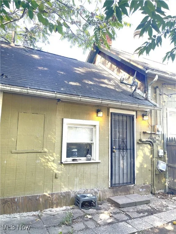 Entrance to property with a shingled roof
