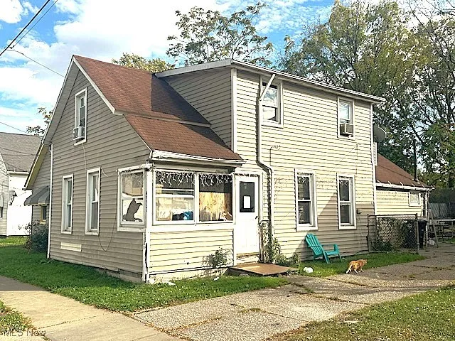 View of front of home featuring a front lawn and a shingled roof