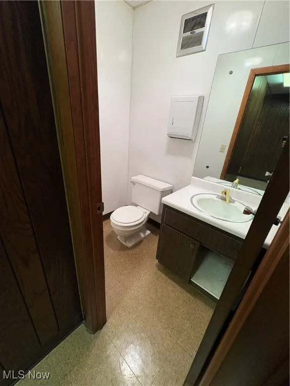 Half bathroom with vanity and light flooring