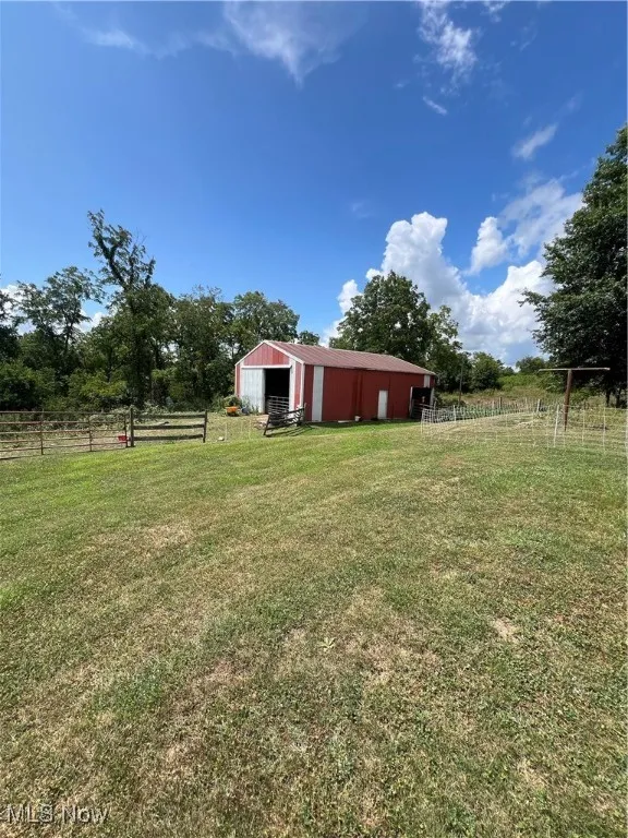 View of yard featuring a rural view and an outbuilding