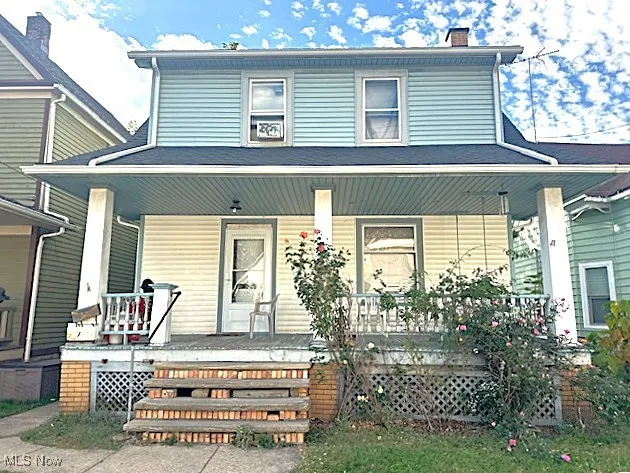 View of front of house featuring covered porch and a chimney