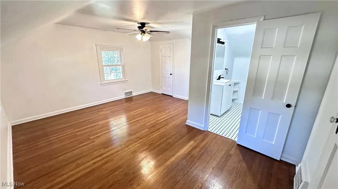 Bonus room featuring dark wood finished floors and a ceiling fan