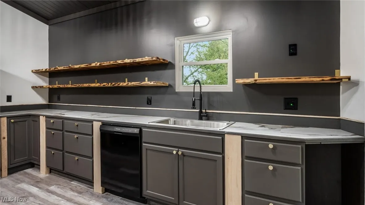 Kitchen with gray cabinets, open shelves, and black dishwasher