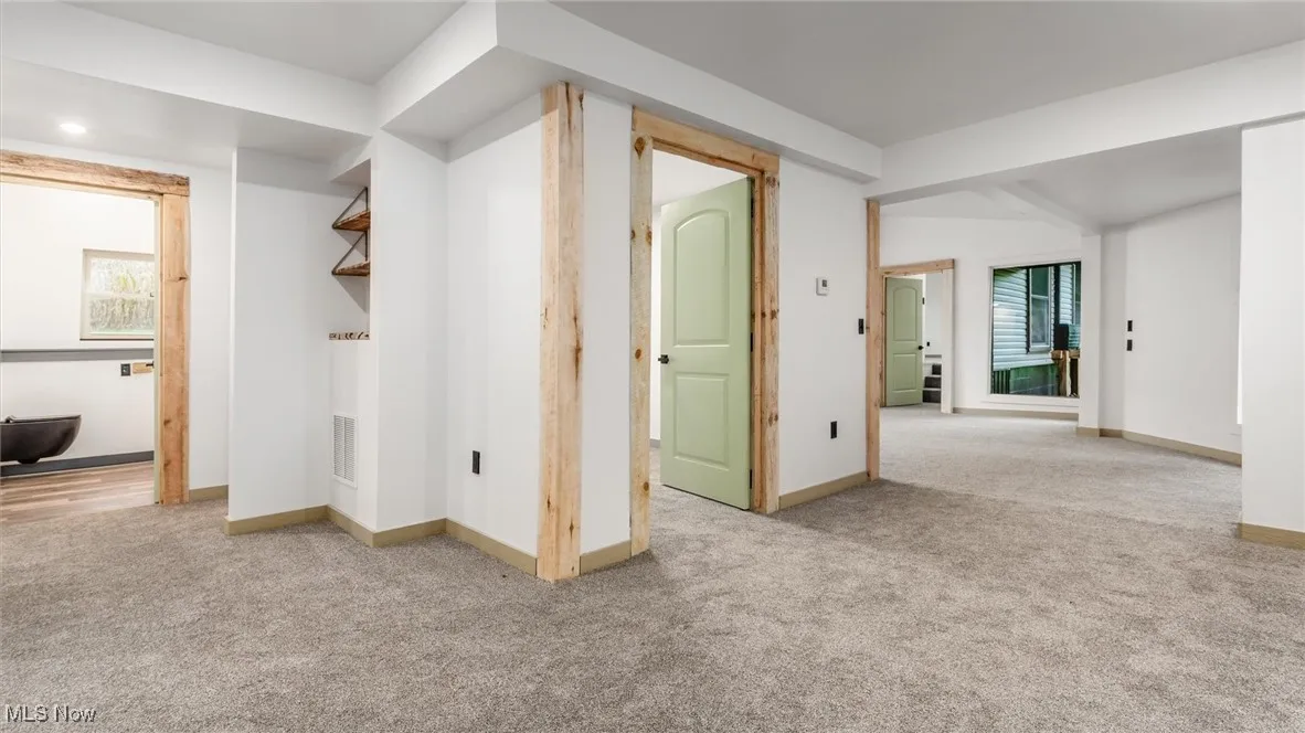 Unfurnished room with light colored carpet and baseboards