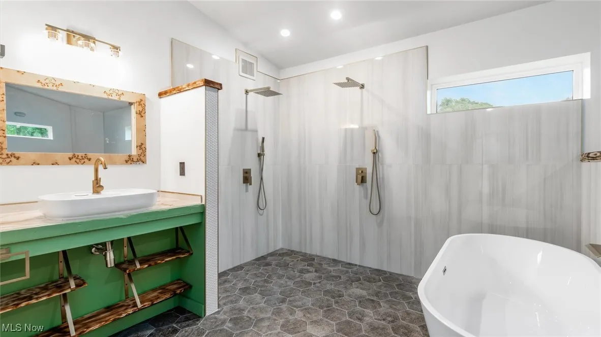 Full bath featuring a walk in shower and a soaking tub