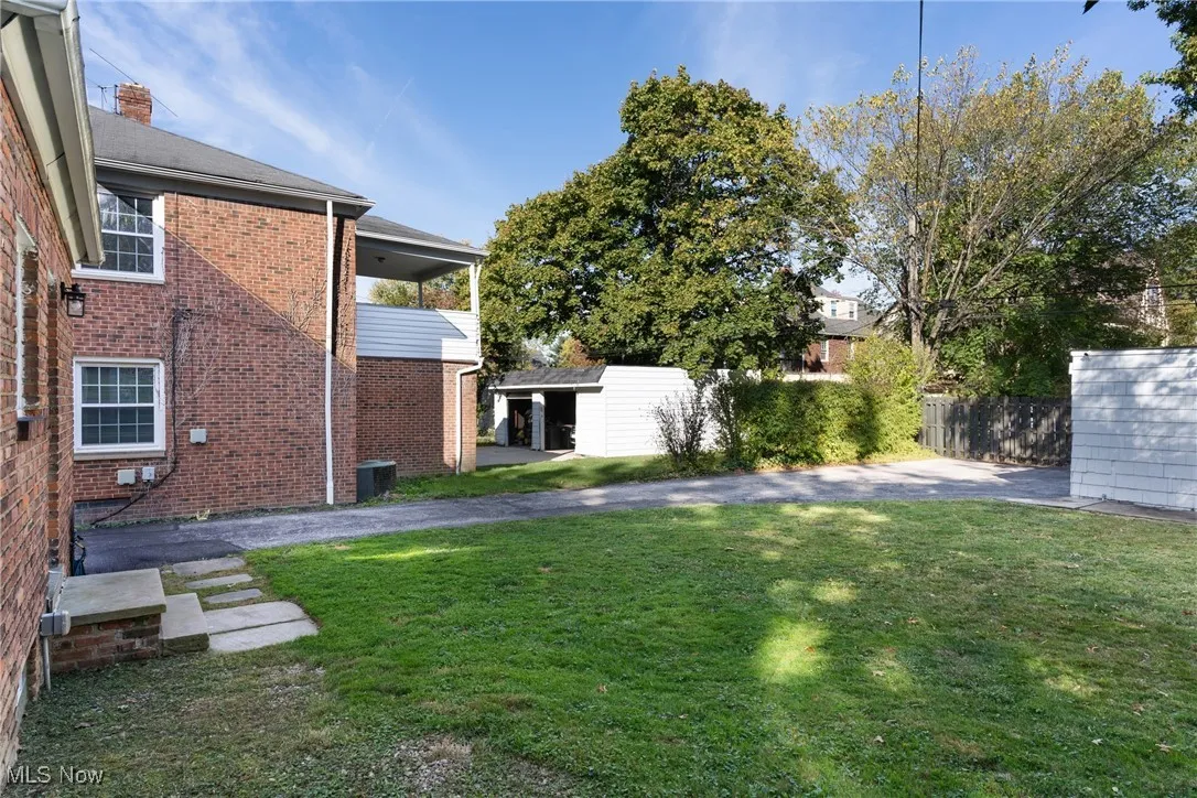 View of yard featuring a balcony, a patio area, and an outdoor structure