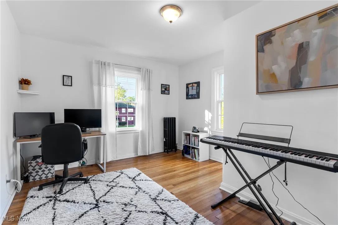 Office featuring radiator and light wood-style floors