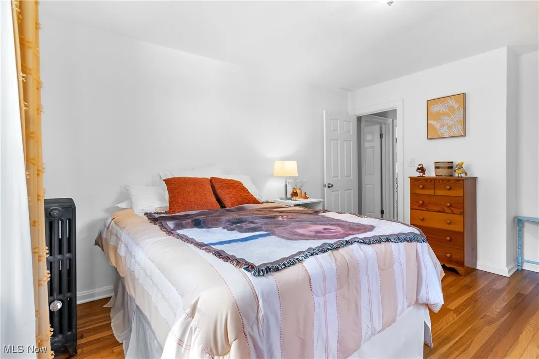 Bedroom featuring wood finished floors and radiator