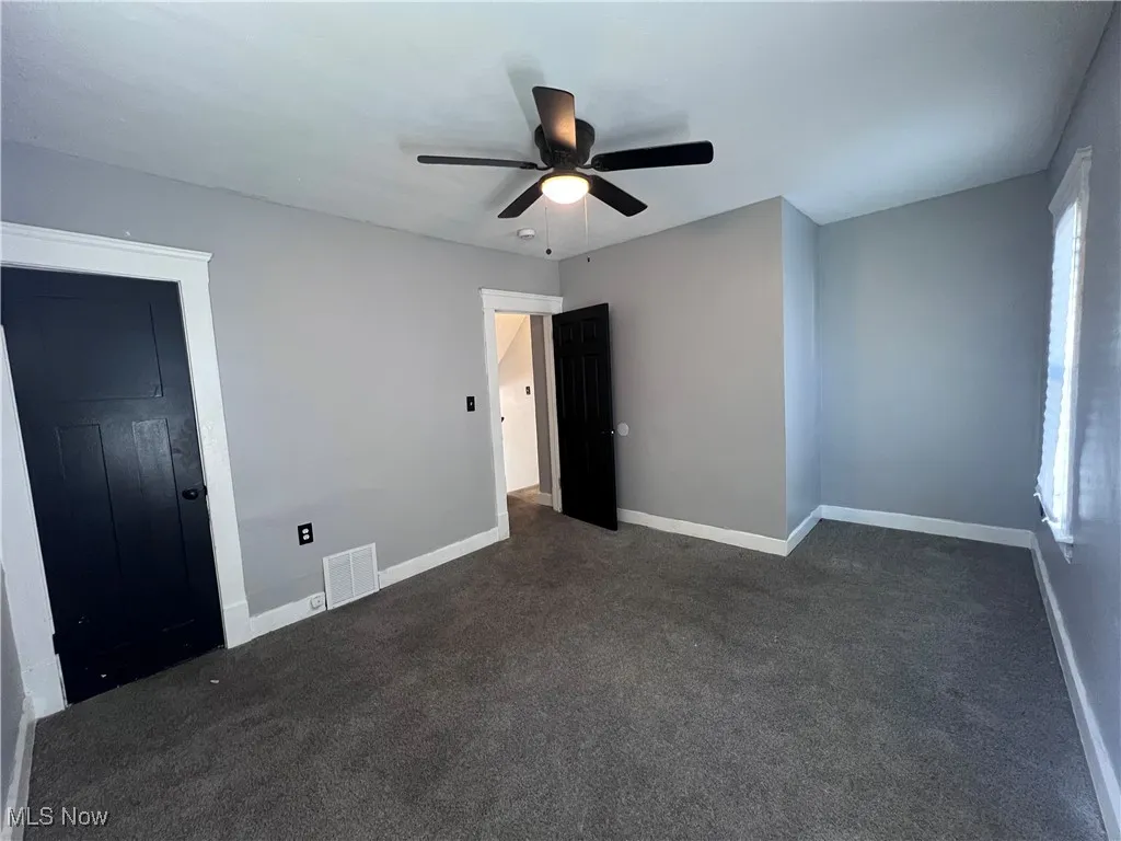 Unfurnished bedroom with carpet and ceiling fan