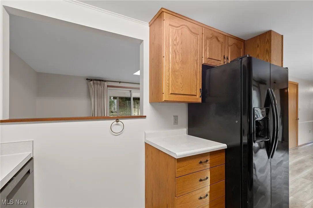 Kitchen featuring light countertops and black fridge with ice dispenser