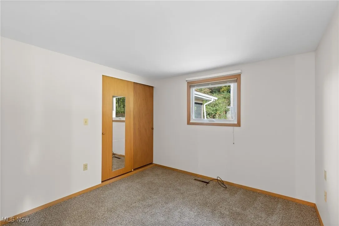 Spare room with carpet and baseboards