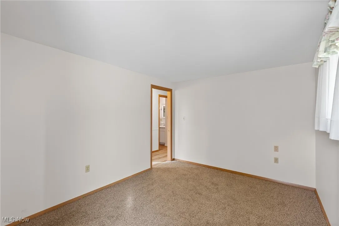 Empty room featuring baseboards and carpet