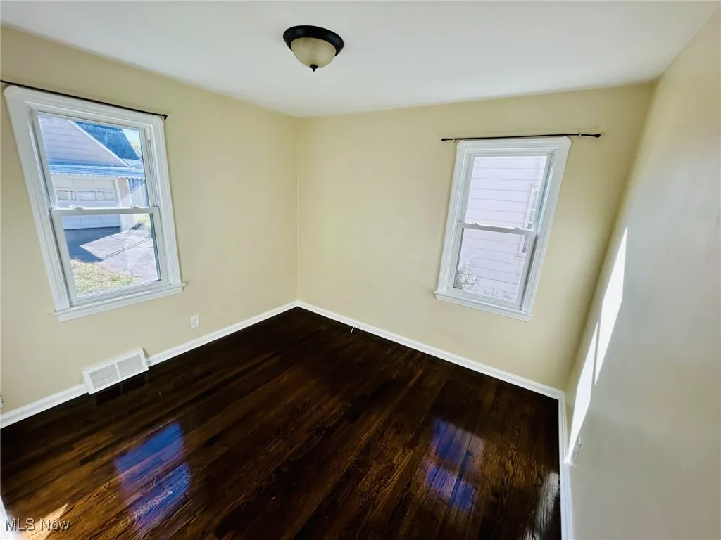 Empty room with dark wood-style flooring