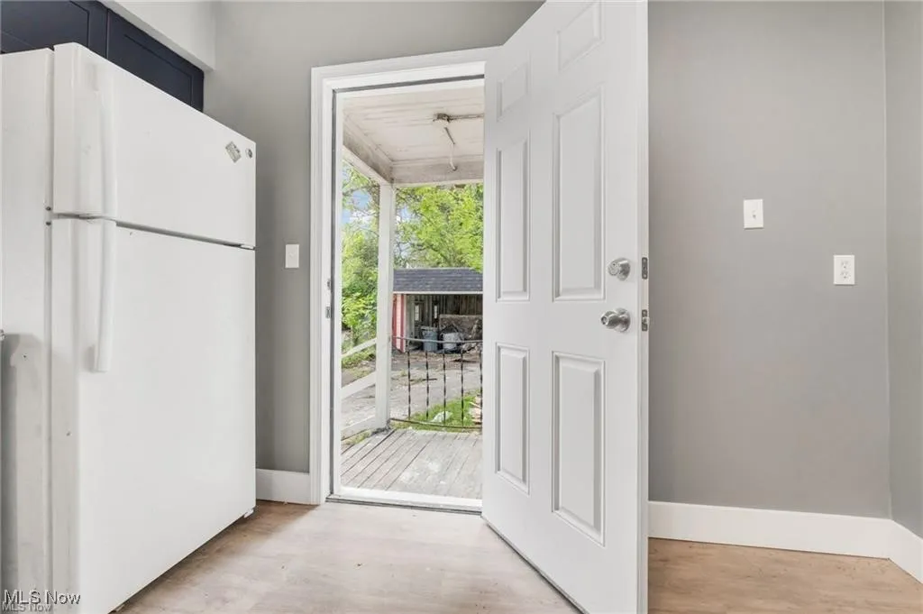 Doorway to outside with wood finished floors and baseboards