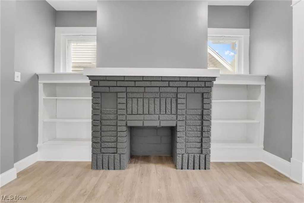 Detailed view of wood finished floors and a fireplace