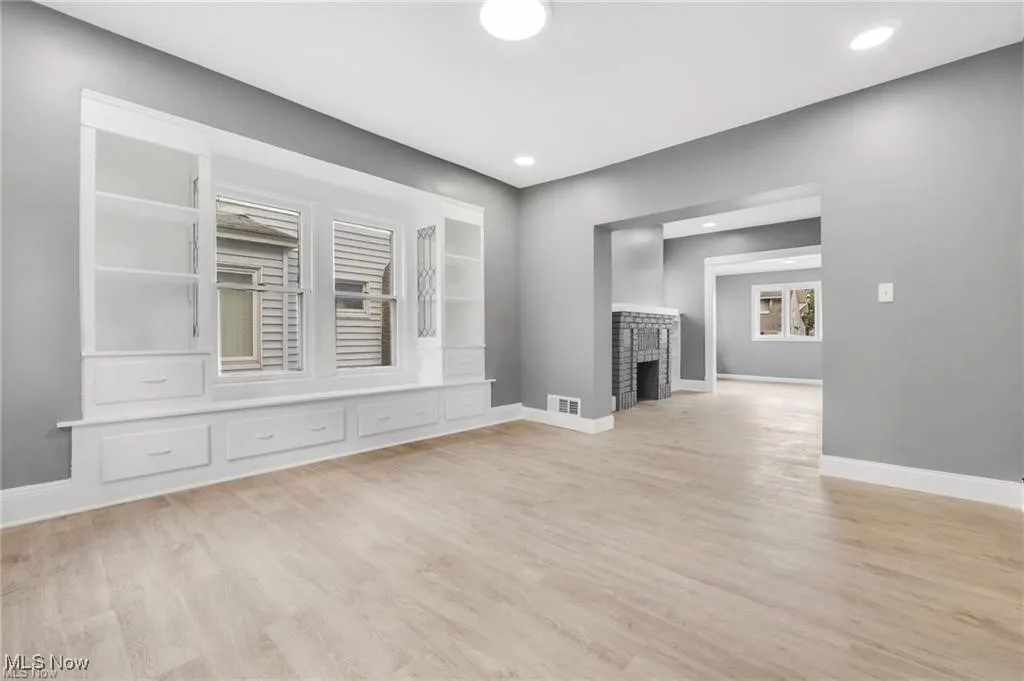 Unfurnished living room with light wood-type flooring, a fireplace, and recessed lighting