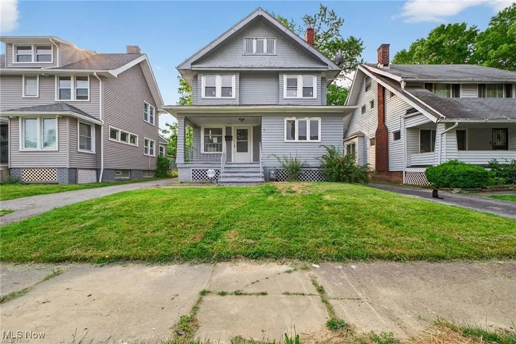 American foursquare style home with a porch and a front lawn