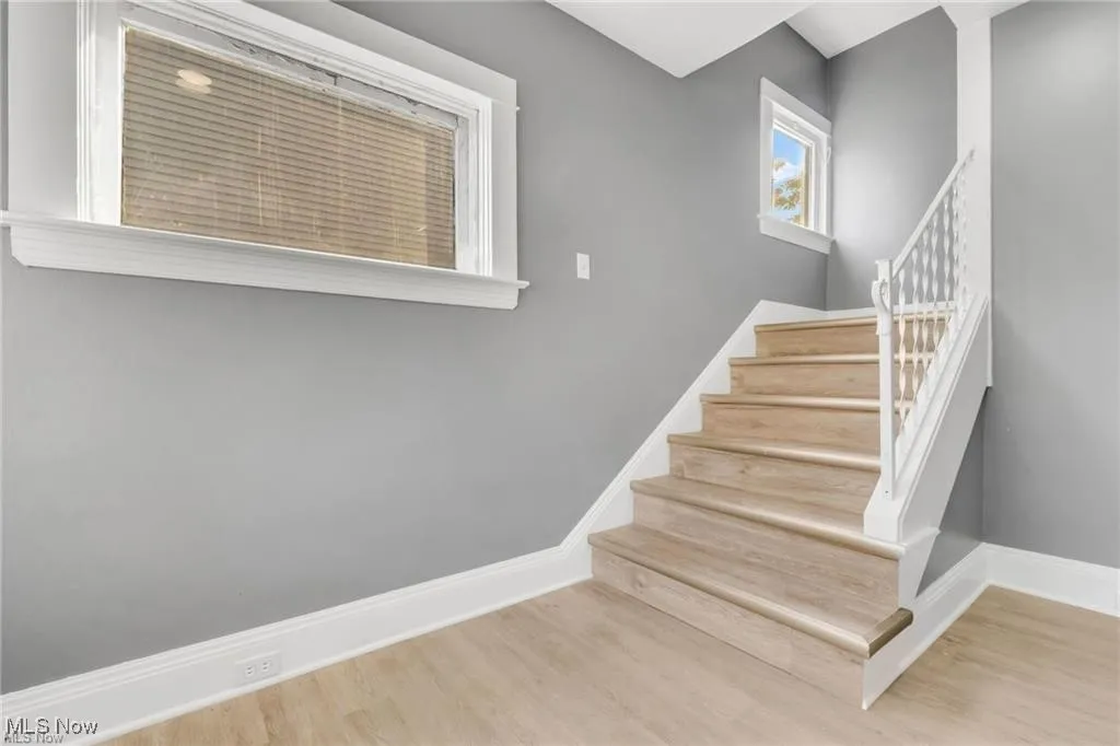 Staircase with baseboards and wood finished floors