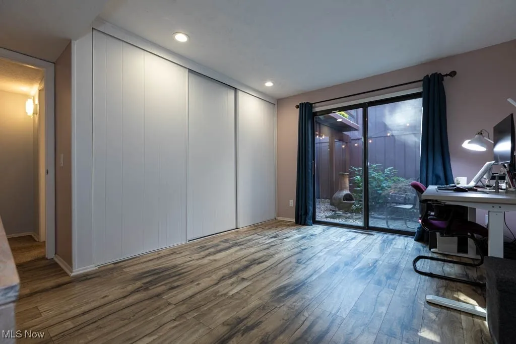 Office with wood finished floors and recessed lighting
