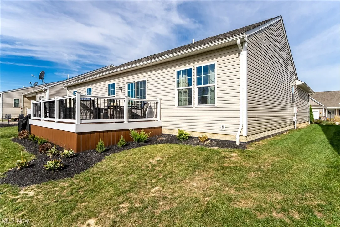 Rear view of property with a deck and a lawn