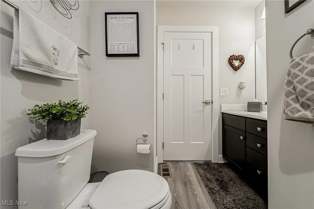 Half bathroom featuring vanity and wood finished floors