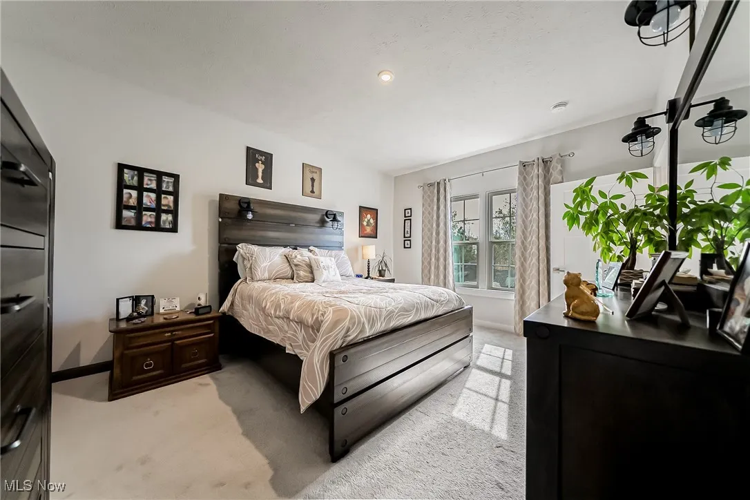 Bedroom featuring light colored carpet and baseboards