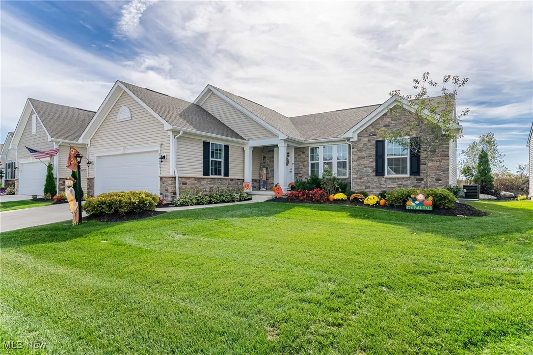 View of front of property with stone siding and a front yard