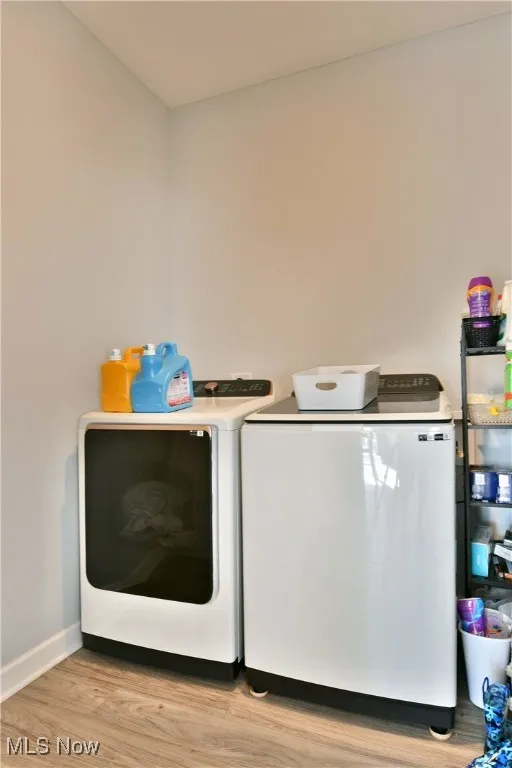Laundry area featuring light wood-style flooring and washer and clothes dryer