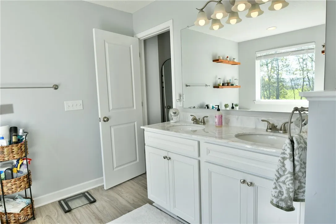 Full bathroom featuring double vanity and light wood-style flooring