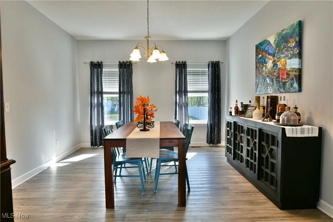 Dining room with light wood-type flooring and a chandelier