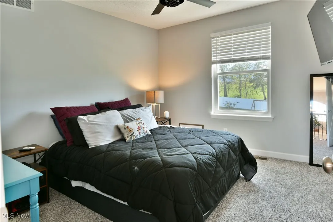 Bedroom featuring carpet flooring, ceiling fan, and a textured ceiling
