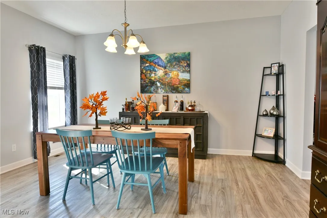 Dining room featuring light wood-style flooring and a chandelier