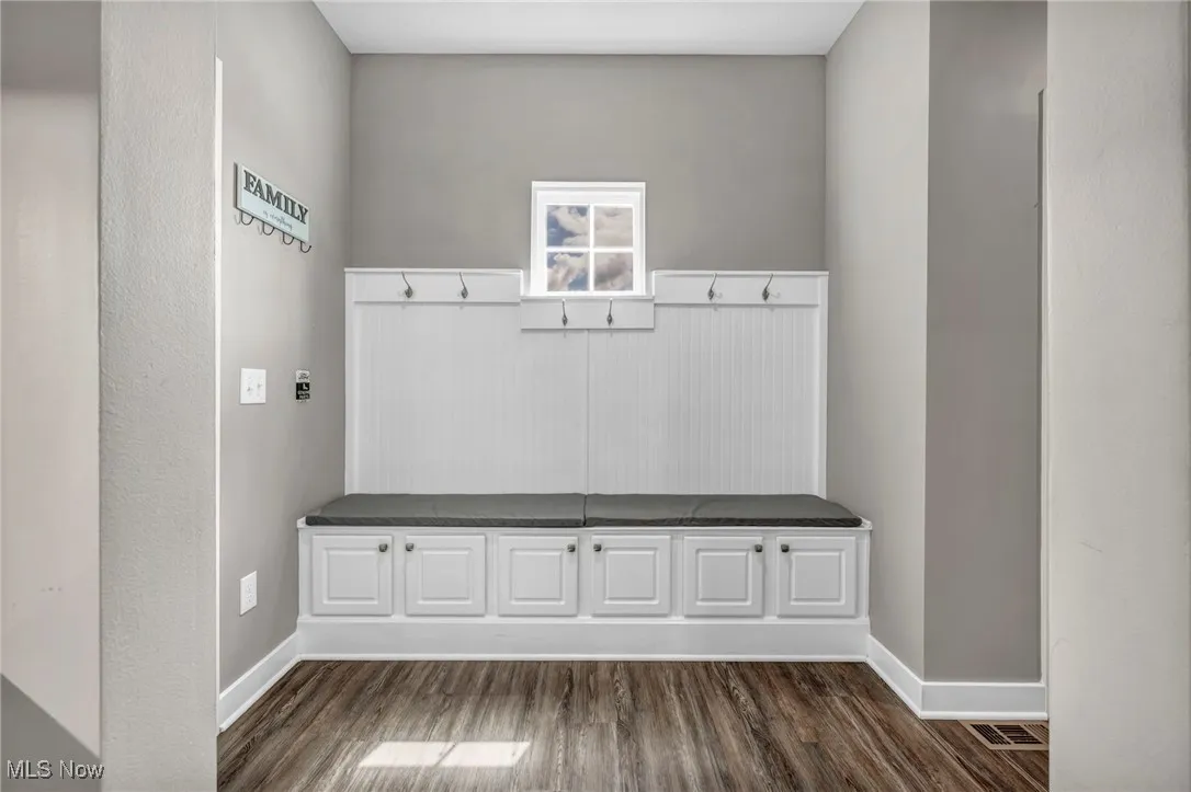 Mudroom featuring dark wood-style flooring and baseboards