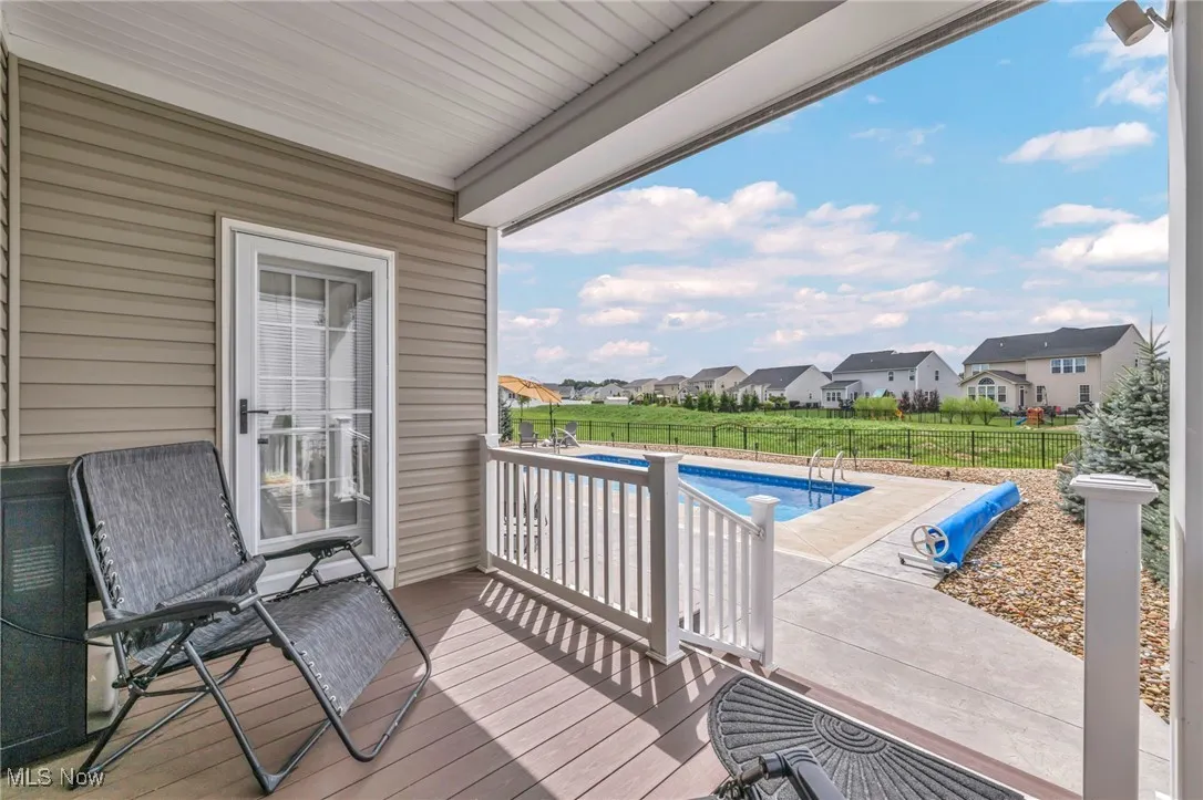Balcony with a sunroom, a residential view, and view of pool area