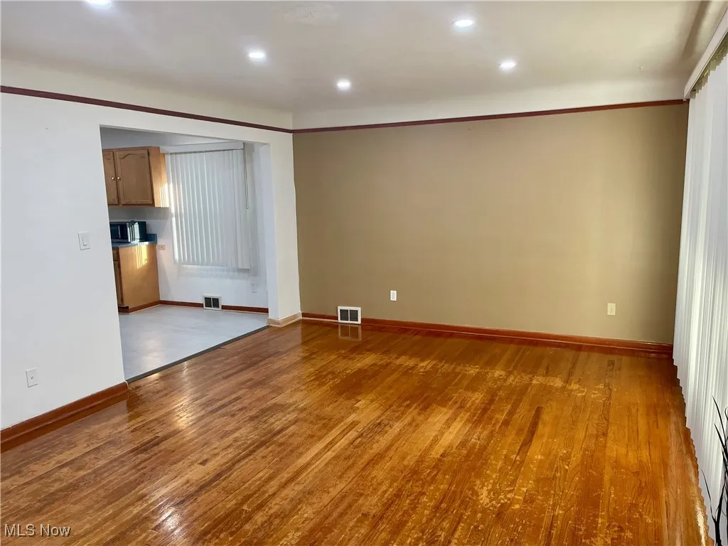 Living room with recessed lighting finished floors, and ornamental molding