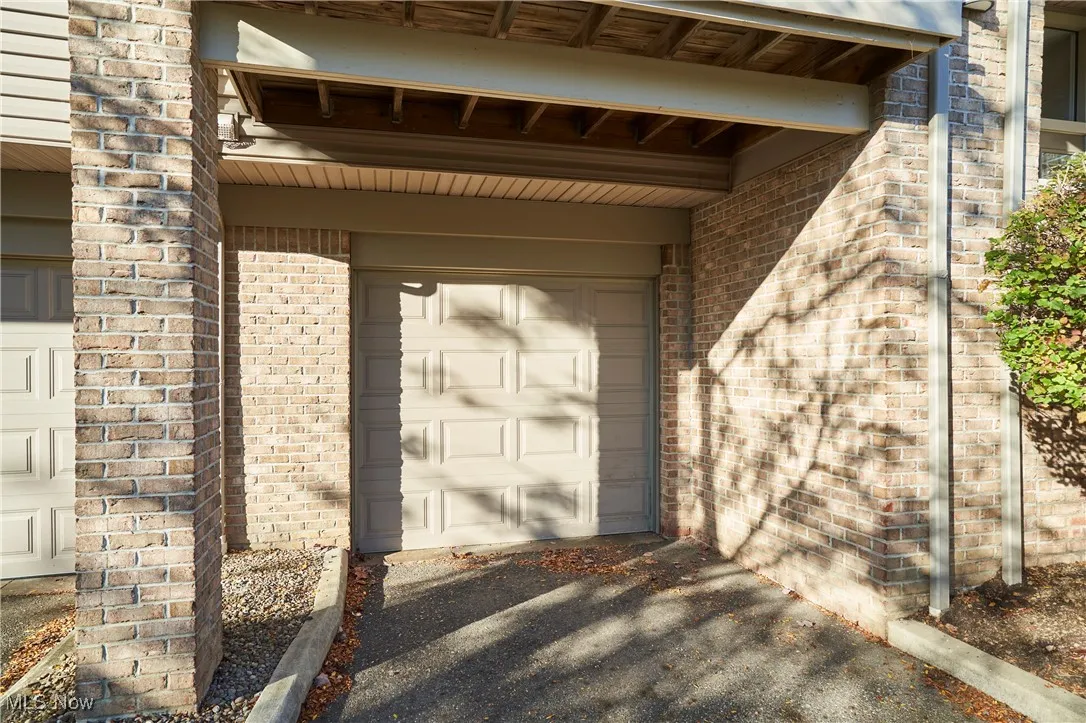 Entrance to property featuring brick siding and a garage
