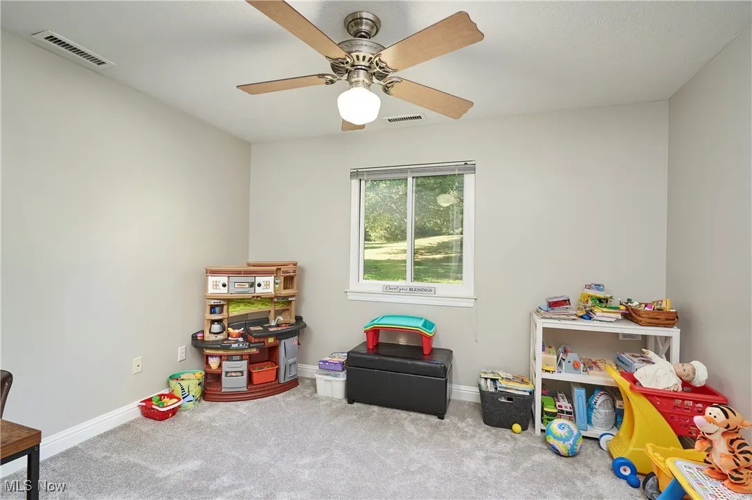 Recreation room with carpet flooring and baseboards