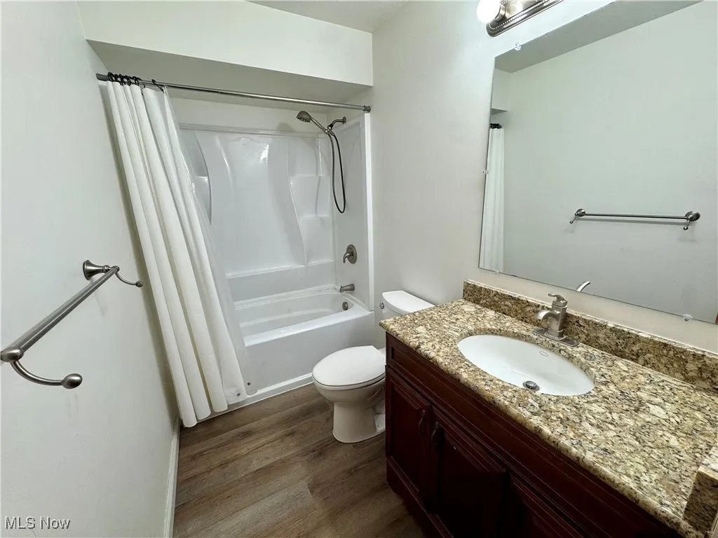 Bathroom with vanity, dark wood finished floors, and shower / bath combo