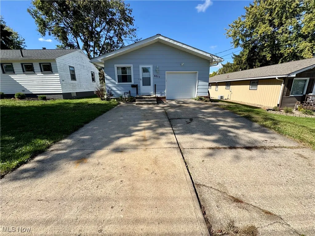 View of front of home with concrete driveway and a front yard