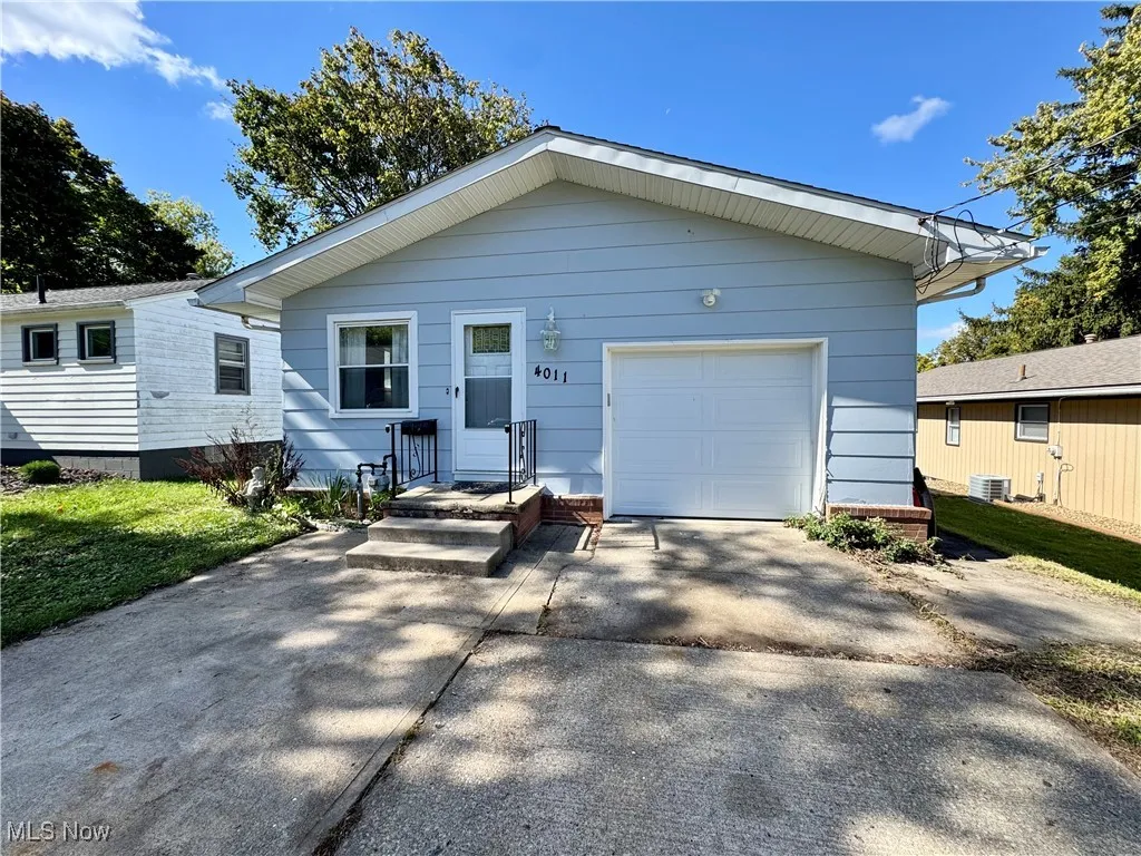 View of front of house with concrete driveway and a garage
