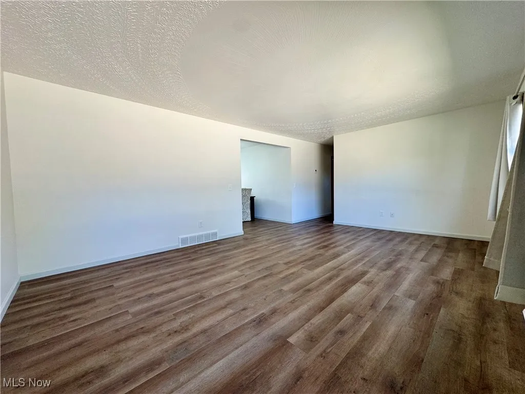 Unfurnished room featuring a textured ceiling and wood finished floors