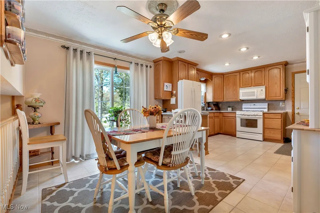 Dining room with light tile patterned floors, recessed lighting, a ceiling fan, ornamental molding, and a textured ceiling